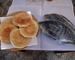Auf dem Gabentisch sind auch zwei Fische und fünf Brote.